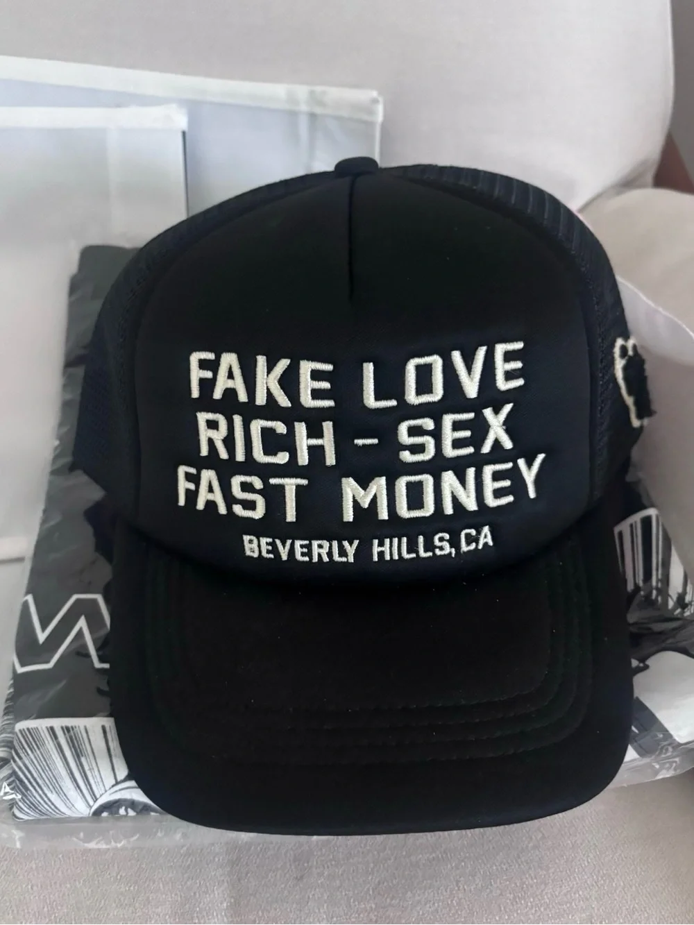 Black Trucker hat with White Embroidery. Homme + Femme “fake love”